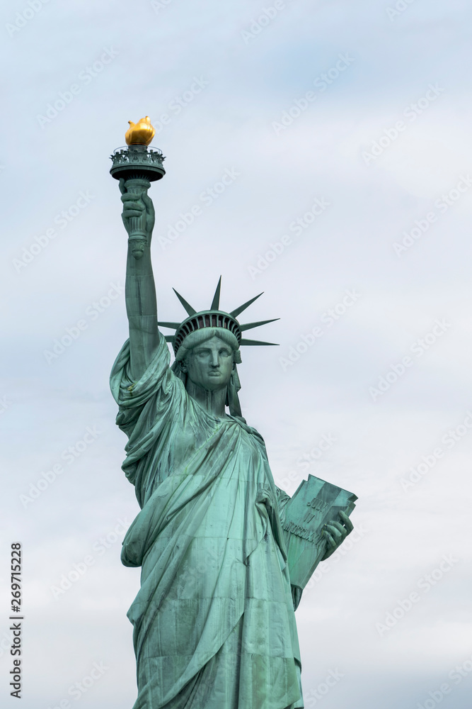 Fototapeta premium USA, New York - May 2019: Statue of Liberty, Liberty Island against an overcast sky