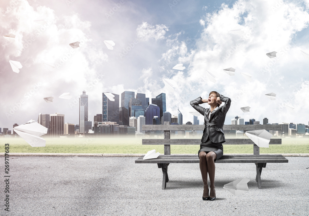 Stressful woman sitting on wooden bench Stressful woman sitting on wooden bench