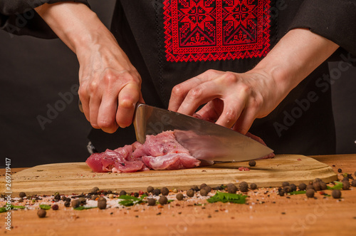 Fototapeta Naklejka Na Ścianę i Meble -  Female hands with a knife in their hand cut fresh meat on a table