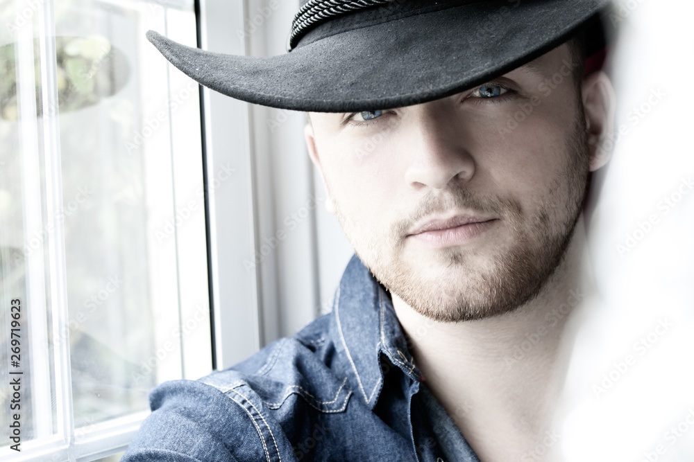 Portrait of handsome cowboy with blue shirt and eyes Portrait of handsome cowboy with blue shirt and eyes