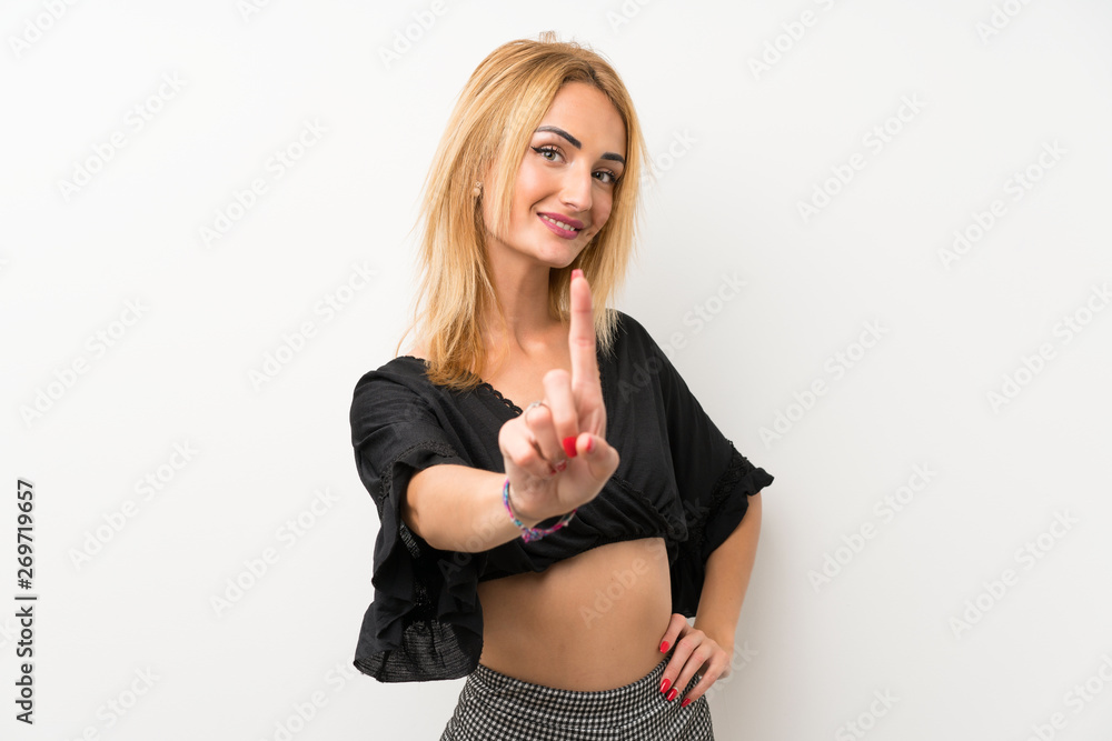 Young blonde woman over isolated white wall showing and lifting a finger Young blonde woman over isolated white wall showing and lifting a finger