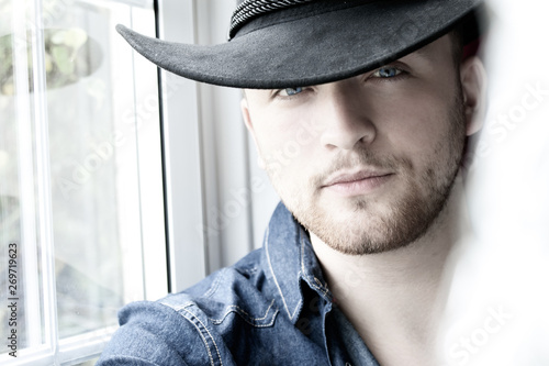 Portrait  of handsome cowboy with blue shirt and eyes  photo