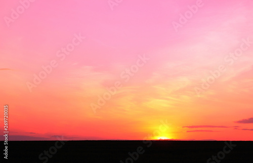 Photo of beautiful bright red color-rich tropical sunset in summer in nice slightly cloudy weather with space for writing advertising text or advertising slogan for travel agency or tour operator