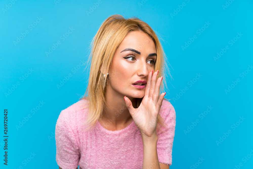 Young blonde woman over blue background whispering something Young blonde woman over blue background whispering something