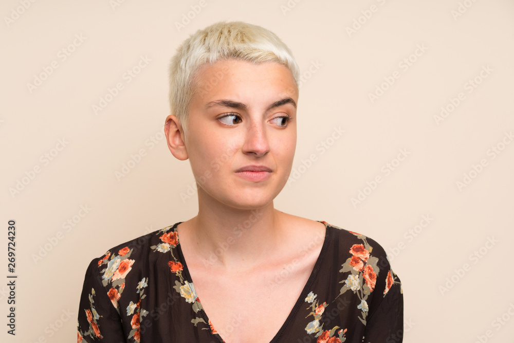 Young woman over isolated wall standing and looking to the side Young woman over isolated wall standing and looking to the side