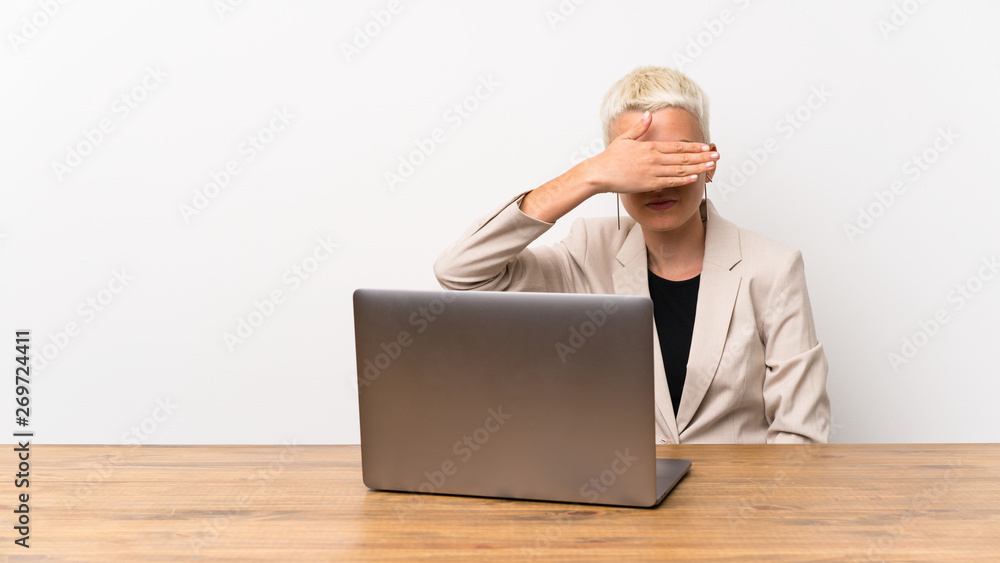Teenager girl with short hair with a laptop covering eyes by hands. Do not want to see something Teenager girl with short hair with a laptop covering eyes by hands. Do not want to see something