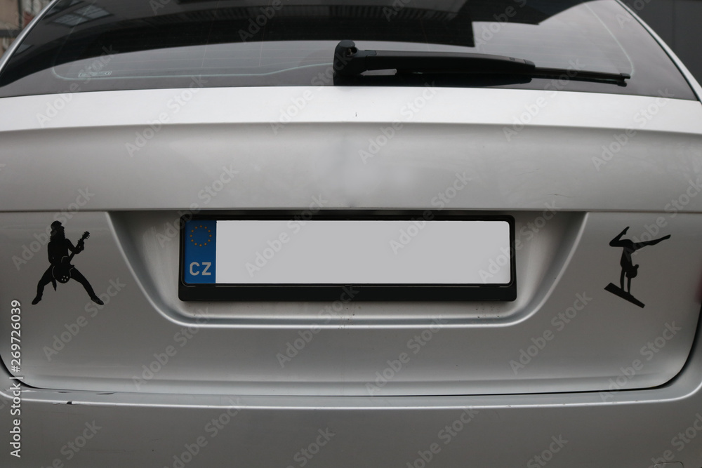 Empty License plate on the back of a grey silver car with stickers Empty License plate on the back of a grey silver car with stickers