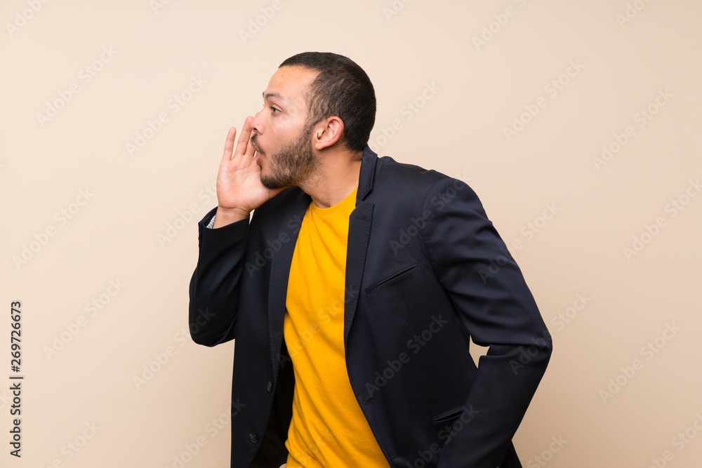 Colombian man over isolated background shouting with mouth wide open Colombian man over isolated background shouting with mouth wide open