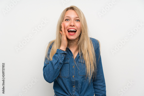 Young blonde woman over isolated white wall with surprise and shocked facial expression