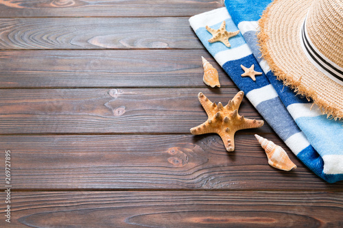 Straw hat, blue towel and starfish On a dark wooden background. top view summer holiday concept with copy space