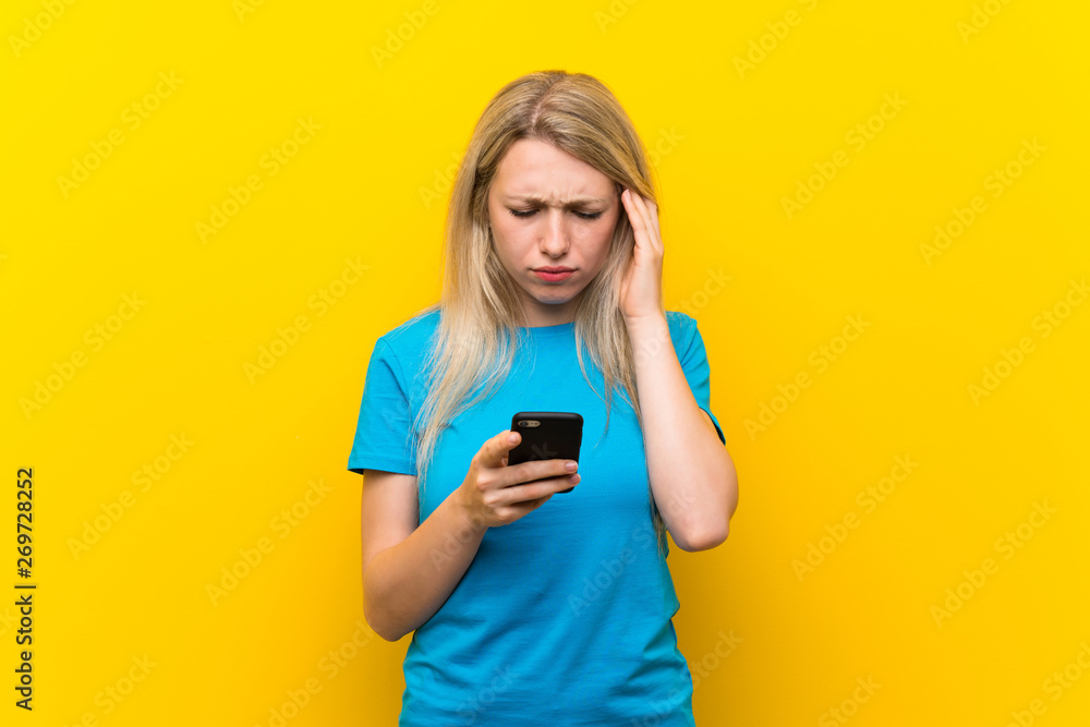 Young blonde woman over isolated yellow background thinking and sending a message Young blonde woman over isolated yellow background thinking and sending a message