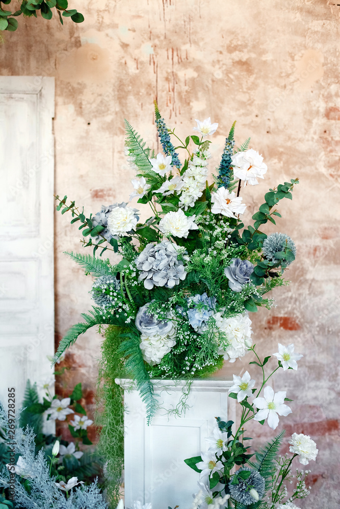 Flower decoration. Wedding decor. Flower interior composition in the studio. Spring photo zone. White doors. 