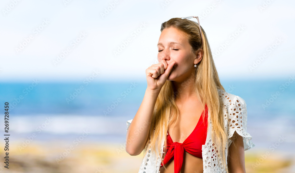 Blonde girl in summer vacation is suffering with cough and feeling bad at the beach Blonde girl in summer vacation is suffering with cough and feeling bad at the beach