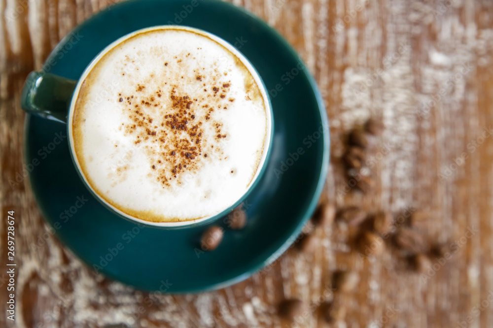 A cup of hot fresh coffee with rich foam on the wooden table A cup of hot fresh coffee with rich foam on the wooden table