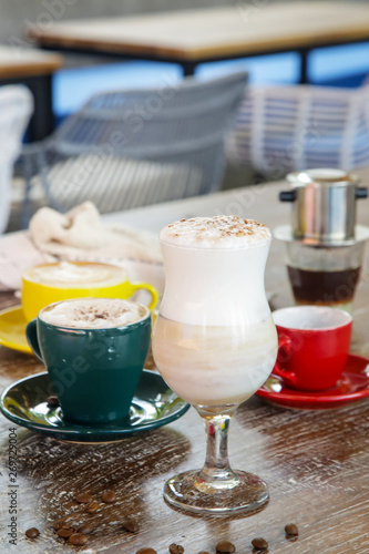 A cup of hot fresh coffee with rich foam on the wooden table