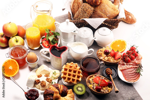 Huge healthy breakfast on table with coffee, orange juice, fruits, waffles and croissants. Good morning concept.