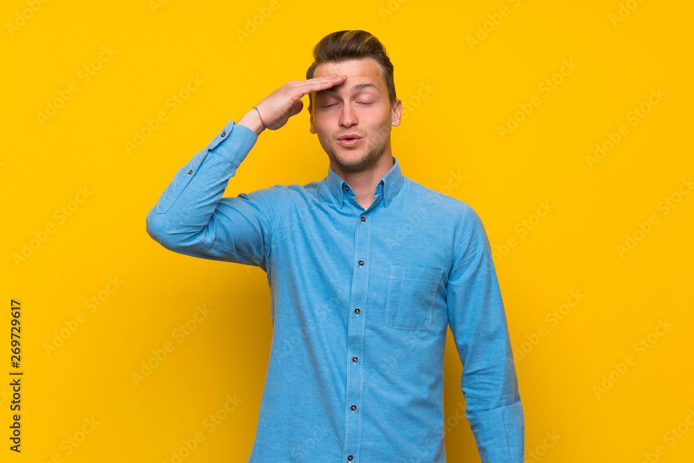 Blonde man over isolated yellow wall has just realized something and has intending the solution Blonde man over isolated yellow wall has just realized something and has intending the solution