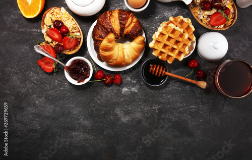 Huge healthy breakfast on table with coffee, orange juice, fruits, waffles and croissants Fototapeta