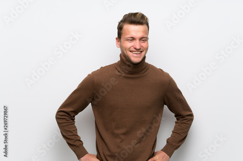 Blonde man over isolated white wall happy and smiling