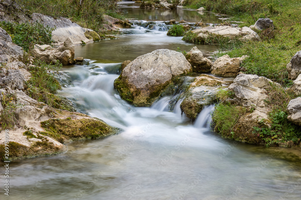 Fototapeta premium Smooth, silky water of long exposure mountain creek in a canyon, close up