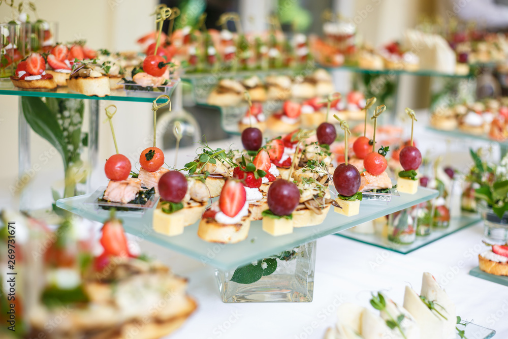 Catering. Off-site food. Buffet table with various canapes, sandwiches, hamburgers and snacks.