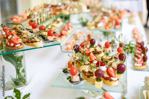 Catering. Off-site food. Buffet table with various canapes, sandwiches, hamburgers and snacks.