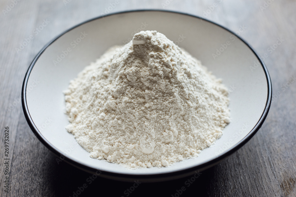  flour in a plate on a wooden background