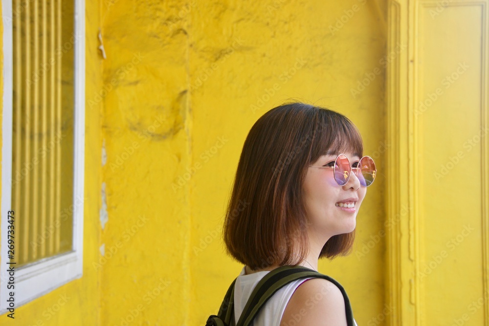 Obraz premium Asian lady female in Melaka Malacca Jonker Street yellow background 