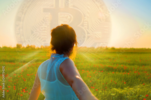 Young woman guides your hand.  View from the back. Bitcoin rise up. photo