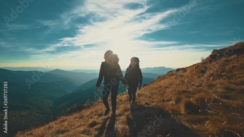 The couple walking along the evening mountain. slow motion