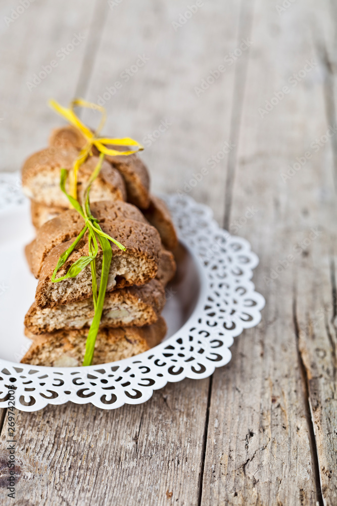 Fresh homemade Italian cookies cantuccini stacked on white plate on ructic wooden table background. Fresh homemade Italian cookies cantuccini stacked on white plate on ructic wooden table background.