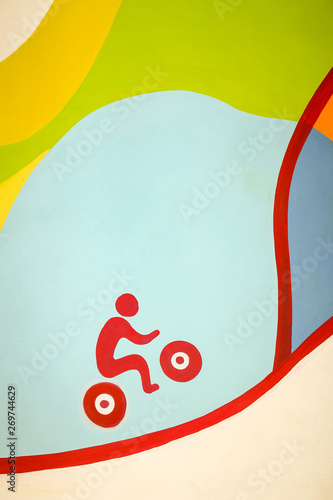 Sketchy picture on the wall of a red bicyclist riding up the hill on a colored background