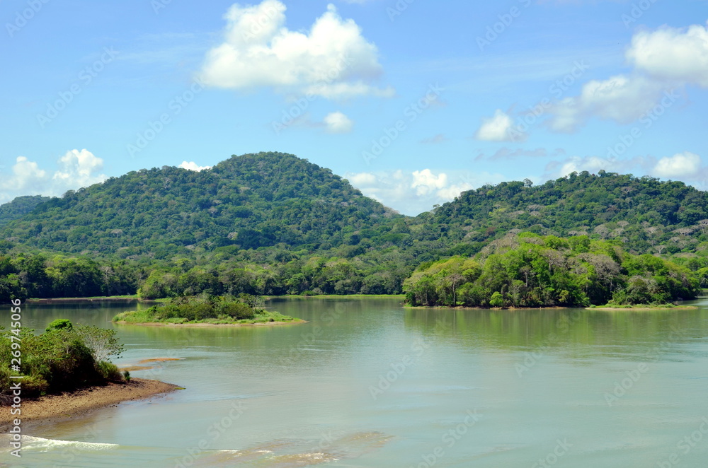 Green landscape of the Panama Canal, view from transiting container ship.