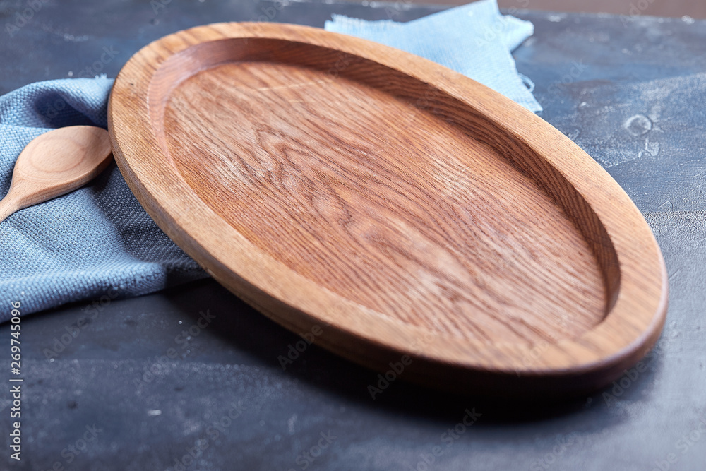 Wooden dish or plate on blue rustic wooden table Wooden dish or plate on blue rustic wooden table