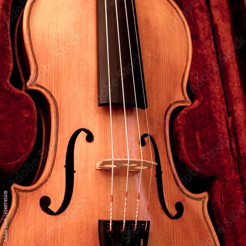 Violin and bow in dark red case. Close up view of violin