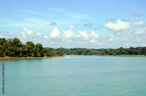 Green landscape of the Panama Canal, view from transiting container ship.
