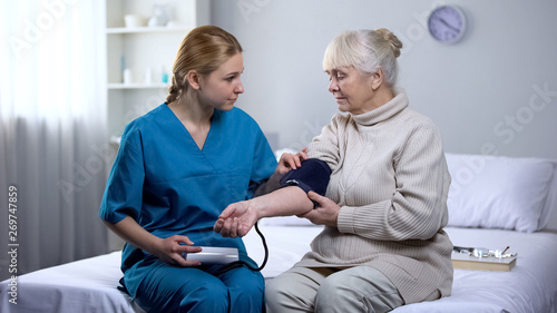 Cardiologist measuring old female patient blood pressure, professional medicare