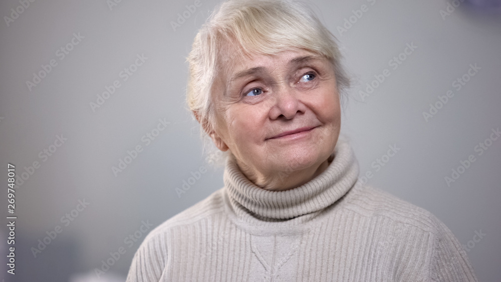 Nostalgic elderly woman sitting alone at room and looking to side, memories Nostalgic elderly woman sitting alone at room and looking to side, memories