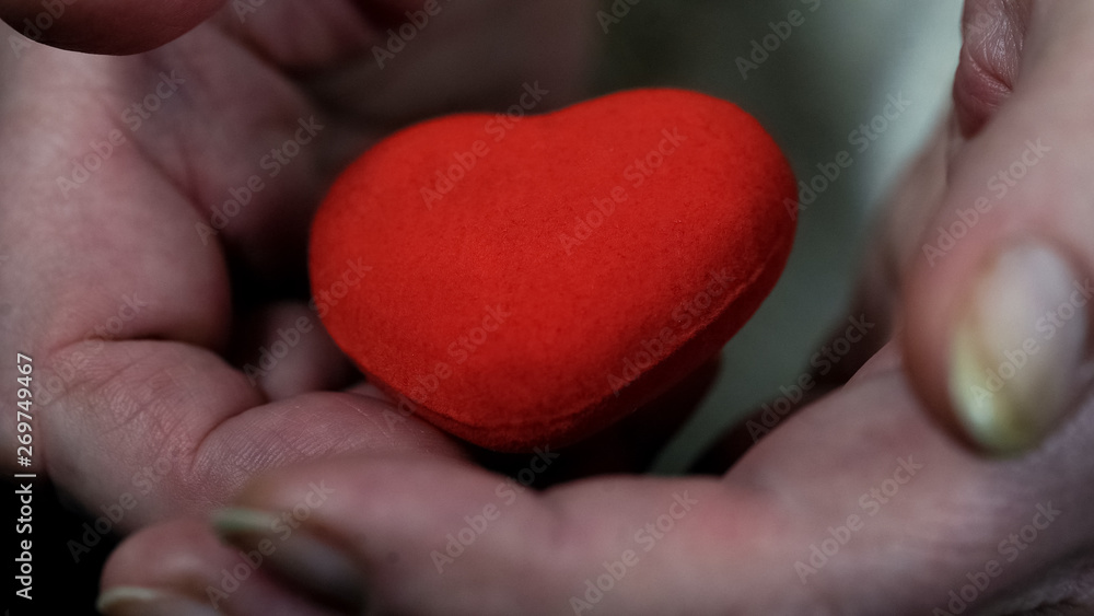 Hands of old woman holding heart sign closeup, charity and donation, kindness Hands of old woman holding heart sign closeup, charity and donation, kindness