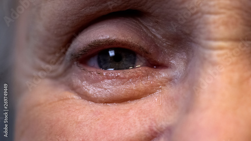 Crying eye of senior wrinkled pensioner, old age depression, retirement problem