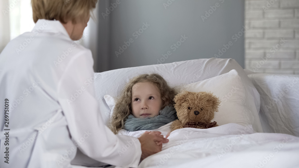 Kind pediatrician examining sick little girl at home, doctor comforting ill kid Kind pediatrician examining sick little girl at home, doctor comforting ill kid