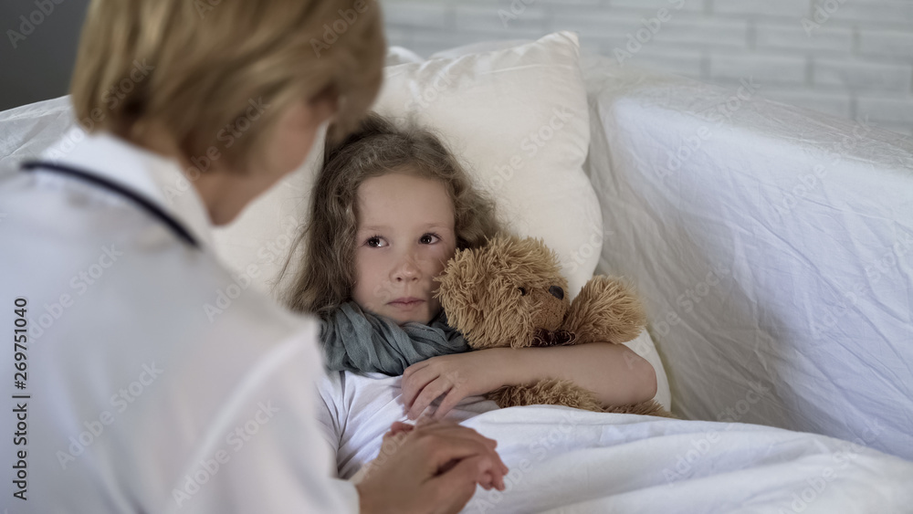 Lady doctor comforting scared little child before examination, medical services Lady doctor comforting scared little child before examination, medical services