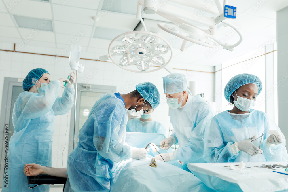 talented professionals people slicing into a person's body to remove an appendix in the clinic