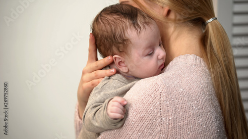 Young mom holding cute baby boy in arms, vaginal birth and natural motherhood
