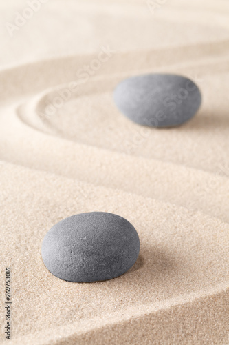 Zen meditation stone in Japanese zen garden. Concept for spirituality, concentration and purity on a minimal sand background..
