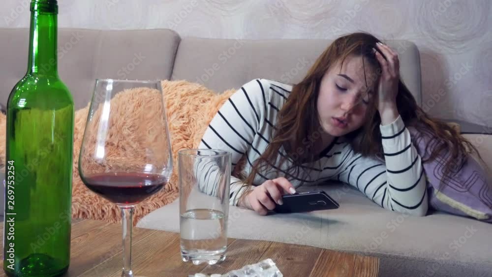 Drunk woman with a headache wakes up after a party, hangover