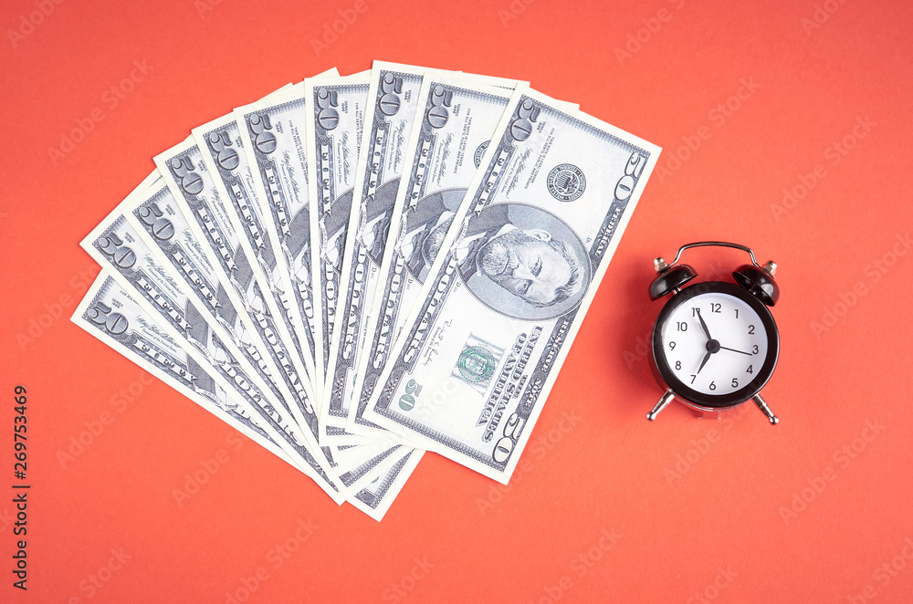 US dollars with clock on red background composition US dollars with clock on red background composition
