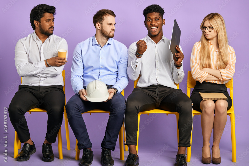 Obraz premium upset and disappointed multicultural young people after job interview and happy dark-skinned man who successfully passed