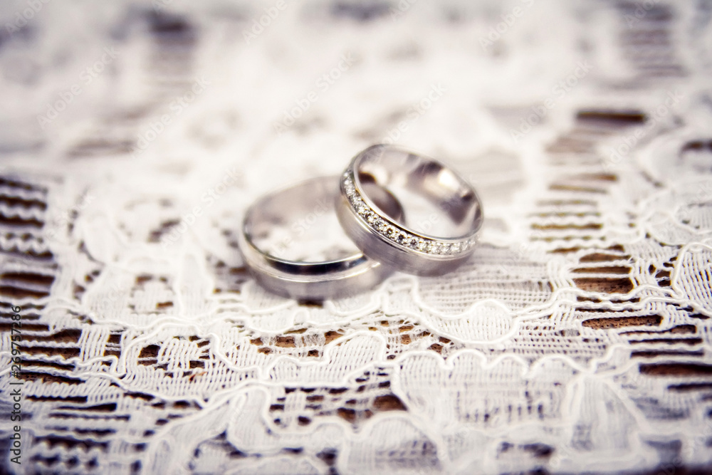 wedding rings. jewelery in white and yellow gold. Wedding ring on satin ribbon. white lace. wedding rings. jewelery in white and yellow gold. Wedding ring on satin ribbon. white lace.