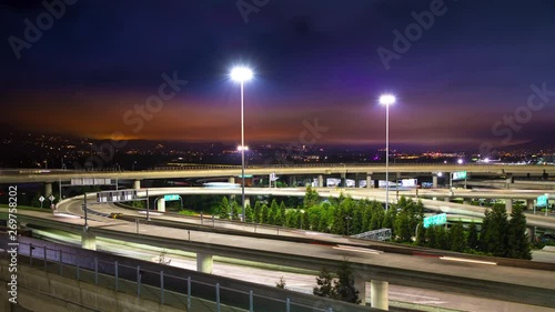 San Francisco Night Interstate Exchange Traffic Timelapse with Streaking Lights from Moving Vehicles Driving Under a Vibrant California Evening Sky